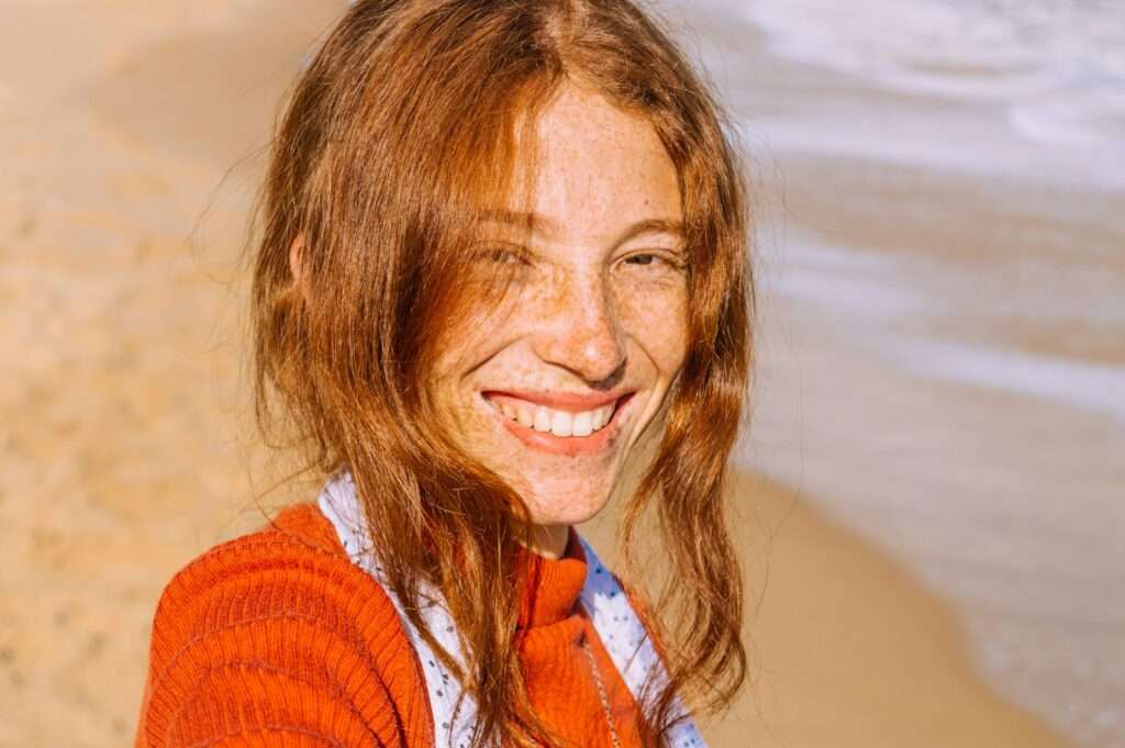 woman in red knit sweater smiling